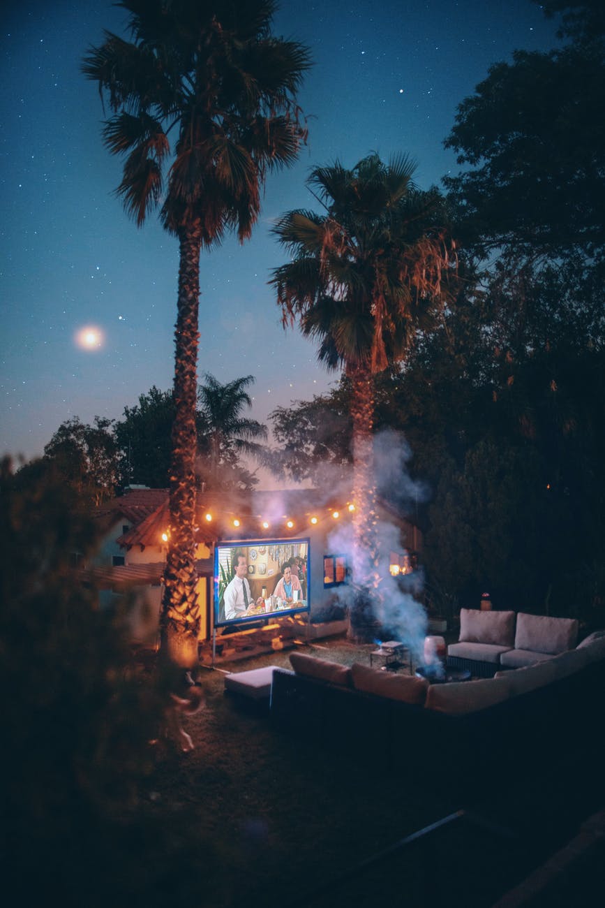 palm trees near projection screen during nighttime